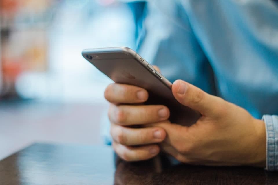 Pessoa usando o celular para acessar um sistema